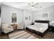 Guest bedroom with a king-size bed, two armchairs, and a ceiling fan at 18391 N 97Th Pl, Scottsdale, AZ 85255