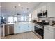 Modern kitchen with white cabinets, stainless steel appliances and island at 19420 W Highland Ave, Litchfield Park, AZ 85340