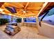 Covered outdoor kitchen with grill, bar seating, and pizza oven, overlooking the pool at 26475 N 106Th Way, Scottsdale, AZ 85255