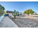 Landscaped front yard with gravel, cactus, and a large tree providing shade at 3609 W Griswold Rd, Phoenix, AZ 85051