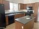 View of kitchen with wood cabinets, dark countertops, and island at 42554 W Lucera Ct, Maricopa, AZ 85138