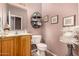 Bathroom with wood vanity, toilet, and decorative accents at 45707 W Barbara Ln, Maricopa, AZ 85139