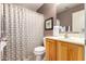 Clean bathroom with shower/tub combo, wood vanity, and patterned shower curtain at 45707 W Barbara Ln, Maricopa, AZ 85139