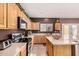 Kitchen with island, stainless steel appliances, and wood cabinets at 45707 W Barbara Ln, Maricopa, AZ 85139