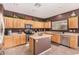 Kitchen with island, stainless steel appliances, and wood cabinets at 45707 W Barbara Ln, Maricopa, AZ 85139