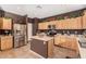 Kitchen with island, stainless steel appliances, and wood cabinets at 45707 W Barbara Ln, Maricopa, AZ 85139