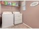 Laundry room with washer, dryer, and ample storage shelving at 45707 W Barbara Ln, Maricopa, AZ 85139