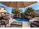 Relaxing poolside patio with seating and a glass top table at 45707 W Barbara Ln, Maricopa, AZ 85139