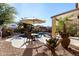 Outdoor patio area with seating and umbrella, adjacent to the pool at 45707 W Barbara Ln, Maricopa, AZ 85139
