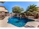 Inviting backyard pool and patio with palm trees and waterfall at 45707 W Barbara Ln, Maricopa, AZ 85139