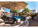 Backyard pool and patio with wicker furniture under an umbrella at 45707 W Barbara Ln, Maricopa, AZ 85139