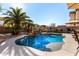 Stunning kidney shaped pool with waterfall feature and palm trees at 45707 W Barbara Ln, Maricopa, AZ 85139