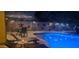 Night view of backyard pool with patio furniture and lighting at 45707 W Barbara Ln, Maricopa, AZ 85139