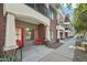 Inviting condo front porch with brick accents, red door and comfortable outdoor seating at 475 N 9Th St # 115, Phoenix, AZ 85006
