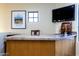 Wet bar with granite countertop, wooden cabinetry, and a TV at 8945 N Cordoniz Ln, Casa Grande, AZ 85194