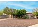 Landscaped front yard with gravel and mature trees at 1103 E Kael Cir, Mesa, AZ 85203