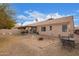 Spacious backyard featuring a covered patio, gravel landscaping, and a designated fire pit area at 11606 W Laurelwood Ln, Avondale, AZ 85392