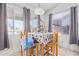 Bright dining area with a table set for four, featuring large windows and tile flooring for easy maintenance at 11606 W Laurelwood Ln, Avondale, AZ 85392