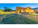 A spacious backyard with a manicured lawn, covered patio, and pool provide the perfect outdoor oasis at 12015 S Tuzigoot Dr, Phoenix, AZ 85044