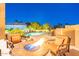 Backyard view with a fire pit surrounded by chairs, desert landscaping, and a swimming pool in the background at 12015 S Tuzigoot Dr, Phoenix, AZ 85044