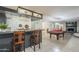 Spacious basement bar with stools, tile flooring, and pool table with fireplace in the background at 12015 S Tuzigoot Dr, Phoenix, AZ 85044