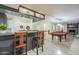 Open basement bar with tile flooring, seating for two, and a pool table in the distance at 12015 S Tuzigoot Dr, Phoenix, AZ 85044