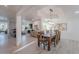 Bright dining area featuring a modern chandelier, wood table and views into the living room at 12015 S Tuzigoot Dr, Phoenix, AZ 85044