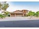 A handsome two-story home with a three-car garage, lush landscaping, and a convenient driveway at 12015 S Tuzigoot Dr, Phoenix, AZ 85044