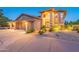 Stunning two-story home boasts an arched entryway, manicured landscaping, and a three-car garage at 12015 S Tuzigoot Dr, Phoenix, AZ 85044