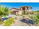 Beautiful two-story home featuring an arched entryway and a well-maintained front yard with mature trees at 12015 S Tuzigoot Dr, Phoenix, AZ 85044