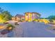 Two-story home featuring a circular driveway, a manicured lawn, desert landscaping and warm exterior lighting at 12015 S Tuzigoot Dr, Phoenix, AZ 85044