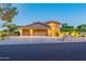 Two-story home featuring a circular driveway, a manicured lawn, desert landscaping and warm exterior lighting at 12015 S Tuzigoot Dr, Phoenix, AZ 85044