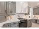 A modern kitchen with gray cabinets, marble countertops and backsplash, and stainless steel appliances at 12015 S Tuzigoot Dr, Phoenix, AZ 85044