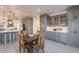 A kitchen and dining area with gray cabinets, marble countertops and backsplash, and a wooden table at 12015 S Tuzigoot Dr, Phoenix, AZ 85044