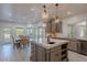 Open kitchen with a large island, gray cabinetry, pendant lighting, and a dining area at 12015 S Tuzigoot Dr, Phoenix, AZ 85044