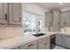 A modern kitchen with gray cabinets, marble countertops and backsplash, and a stainless steel sink at 12015 S Tuzigoot Dr, Phoenix, AZ 85044