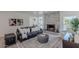 A modern living room with a stone fireplace, a leather sofa, and a patterned rug at 12015 S Tuzigoot Dr, Phoenix, AZ 85044