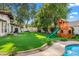 Large backyard with artificial turf, playground set, and a glimpse of the pool at 12286 N 86Th Pl, Scottsdale, AZ 85260