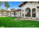 Artificial turf backyard showcasing the home's exterior and arch windows at 12286 N 86Th Pl, Scottsdale, AZ 85260