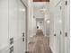 Long hallway with wood-look flooring and white cabinetry at 12286 N 86Th Pl, Scottsdale, AZ 85260