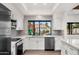 Modern kitchen with white cabinets, stainless steel appliances, and gray backsplash at 12286 N 86Th Pl, Scottsdale, AZ 85260
