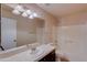 Bathroom with tub, single sink vanity and beige walls at 12465 N 71St Ave, Peoria, AZ 85381