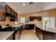 Kitchen with granite island, dark cabinets, and tile floor at 12465 N 71St Ave, Peoria, AZ 85381