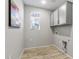 Laundry room with gray cabinets and wood floor at 13616 W Sandridge Dr, Sun City West, AZ 85375
