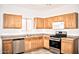 Galley kitchen, featuring wood cabinets and stainless steel appliances at 13915 N 132Nd Ln, Surprise, AZ 85379