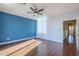 Bedroom with wood floors, ceiling fan, and access to hallway at 14971 W Desert Hills Dr, Surprise, AZ 85379