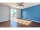 Bright bedroom with wood floors, ceiling fan, and private balcony access at 14971 W Desert Hills Dr, Surprise, AZ 85379