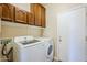 Laundry room with washer, dryer, and upper cabinets at 14971 W Desert Hills Dr, Surprise, AZ 85379