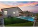 Inviting backyard oasis featuring a sparkling pool and artificial turf at 17838 W Gambit Trl, Surprise, AZ 85387