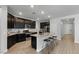 Modern kitchen with dark cabinetry, granite countertops, and stainless steel appliances at 17838 W Gambit Trl, Surprise, AZ 85387